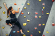 © alfa27 - Active sporty woman practicing rock climbing on artificial rock in climbing s. Extreme sports and bouldering concept.