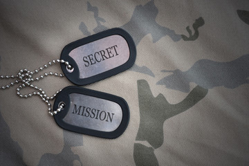 Wall Mural - army blank, dog tag with text secret mission on the khaki texture background.