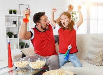 Wall Mural - family of fans watching a football match on TV at home