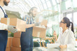 © pressmaster - Serious confident female restaurant manager in glasses asking mover about goods and examining wineglasses shown by movers while taking delivery in lobby of new public establishment.