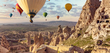 Air Balloons Above Turkish National Park In Goreme. Panorama Of Cappadocia Landscape - Multi Colored Balloons Flying Over Mountain Valley Of Ancient Cave Town Uchisar.