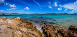 Fototapeta Krajobraz - Panoramic view of a rocky beach with clear colorful water