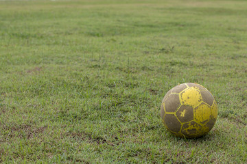 Old yellow football on the lawn.