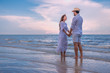 © May Chanikran - Happy young couple holding each other and laughing with enjoying together on the summer beach, we can see the blue sea stretching to the horizon, romantic couple spending time concept.