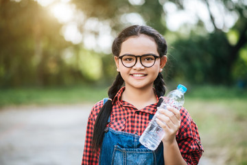 Plastic water bottle in girl hand