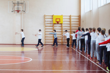 Wall Mural - Primary school children a sport lesson indoors