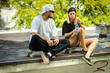 © superelaks - skateboard boy and girl sitting and drinking water on a summer day