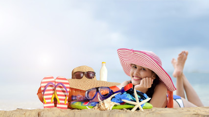 Asian cute girl  relax on the beach and beach accessories on white sandy beach with blue sky .