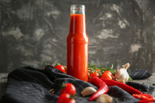 Bottle With Tasty Tomato Sauce And Vegetables On Table