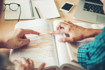 High school or college students studying and reading together in library