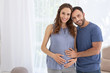 © Viacheslav Yakobchuk - Happy parent. Exuberant pregnant woman and man smiling to camera and touching belly