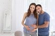 © Viacheslav Yakobchuk - Loving family. Happy pregnant woman and man grinning to camera and touching belly