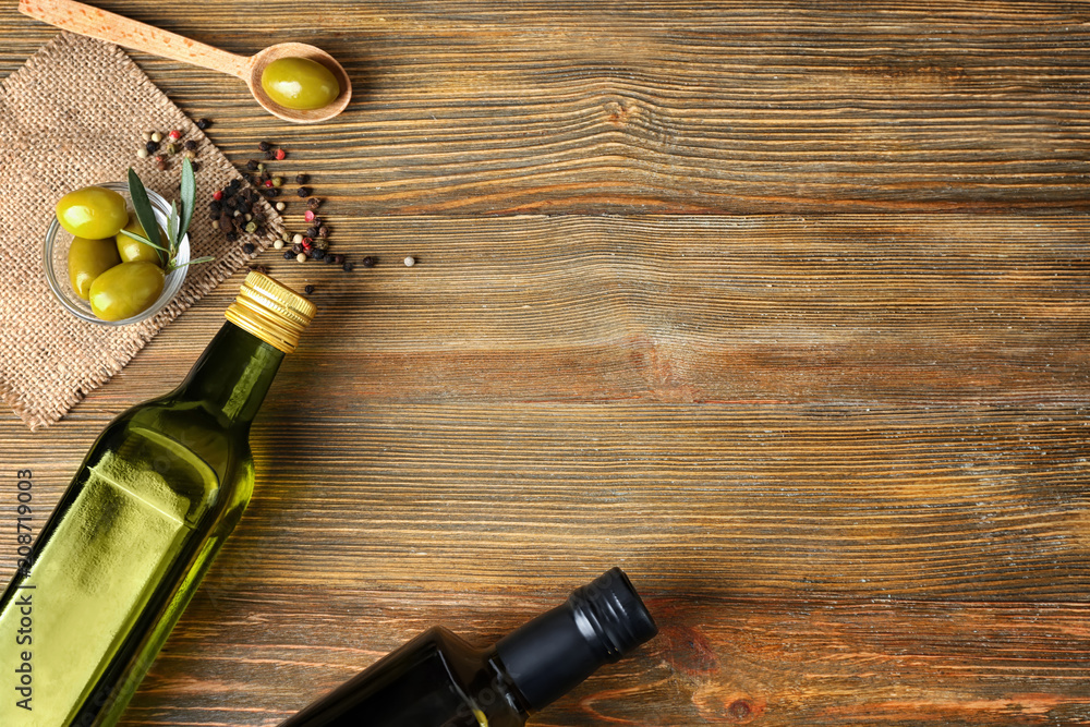 Flat lay composition with olives and oil on wooden background