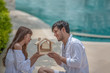 © May Chanikran - Happy smiling couple holding model house with dreaming together.