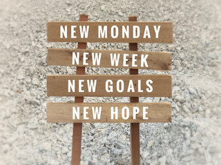 Motivational and inspirational quote - ‘New Monday, new week, new goals, new hope’ written on plank signage. With blurred vintage styled background.