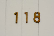 House Number 118 Sign On Wooden Door