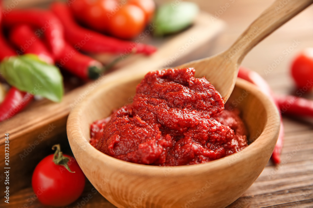 Bowl and spoon with red sauce, closeup