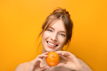 Wall Mural - Beautiful young woman with citrus fruit on color background