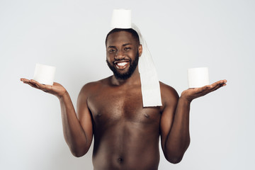 Black man holds roll of toilet paper on head