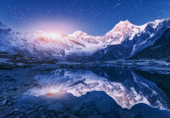 Wall Mural - Night scene with himalayan mountains and mountain lake at starry night in Nepal. Landscape with high rocks with snowy peak and sky with stars and moon reflected in water. Moonrise Beautiful Manaslu