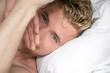 Handsome, sexy good looking man with green eyes first thing in the morning, looking at camera in a bed with white sheets