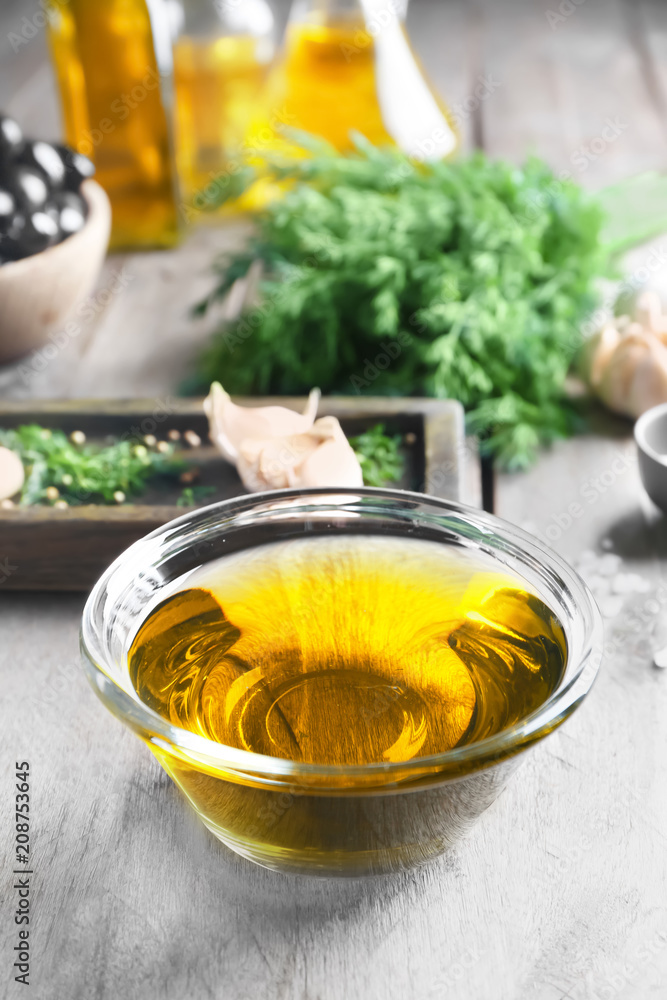 Bowl with olive oil on wooden table