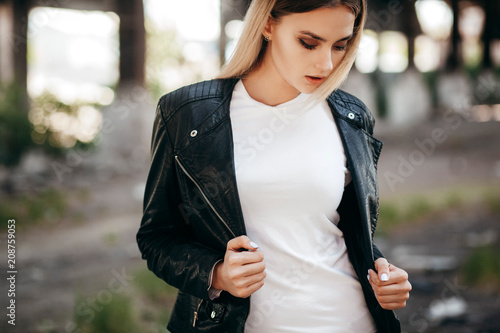 Girl wearing t,shirt and leather jacket posing against