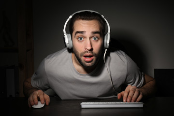 Wall Mural - Young man playing video games on computer at home