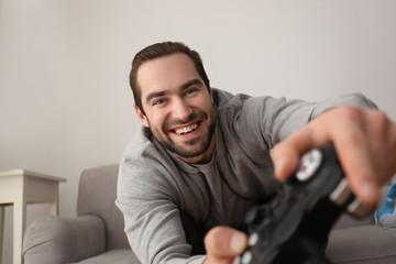 Wall Mural - Young man playing video games at home