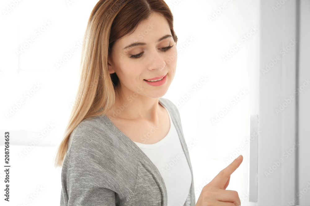 Woman using security system indoors
