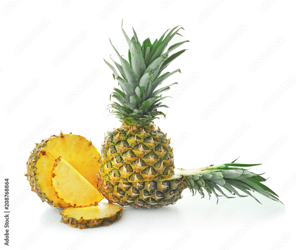 Delicious cut and whole pineapples on white background