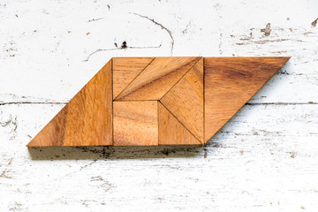 Wall Mural - Tangram puzzle in parallelogram shape on old white wood background