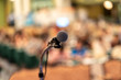 © THANANIT - Microphone over the Abstract blurred photo of conference hall or seminar room with audience background, education and learning concept