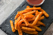 Sweet potato fries and ketchup sauce on wooden table