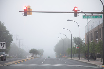 Two red traffic lights on a foggy day