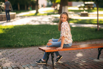 Wall Mural - young teenage girl sits on the bench
