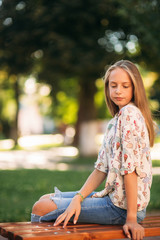 Wall Mural - young teenage girl sits on the bench
