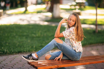 Wall Mural - young teenage girl sits on the bench