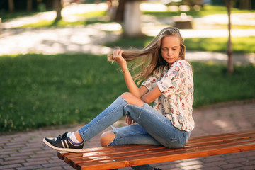 Wall Mural - young teenage girl sits on the bench