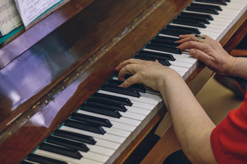 elderly woman playing the old piano