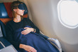 © luengo_ua - Traveling at first class. Flight with comfort. Pretty young  woman sleeping in airplane.