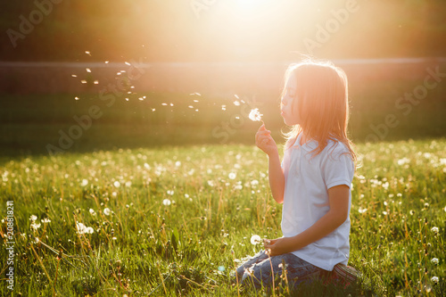 Foto  Little girl blowing dandelion.