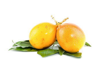 two ripe exotic fruits of a yellow granadilla, refreshing snack dessert with green leaves on a white background