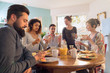 © jackfrog - Group of multi-ethnic friends gathered around a table for breakfast