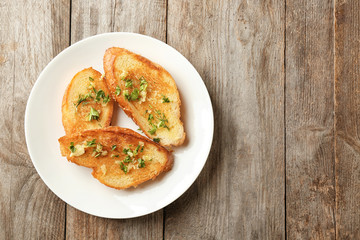 Poster - Plate with delicious homemade garlic bread on wooden background