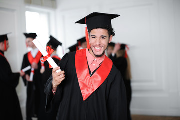 Poster - Happy student in bachelor robe with diploma indoors. Graduation day