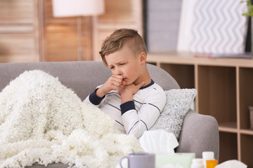 Wall Mural - Little boy with cough suffering from cold on sofa at home