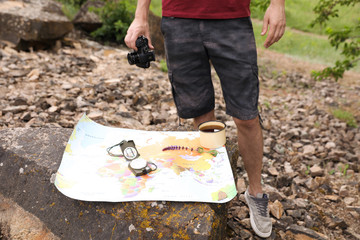 Poster - Man with camera near map in wilderness. Camping season