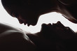 © LIGHTFIELD STUDIOS - side view of silhouettes of interracial couple in love looking at each other
