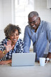 © trinettereed/Stocksy - Senior African American couple doing a video chat with family on computer in the kitchen